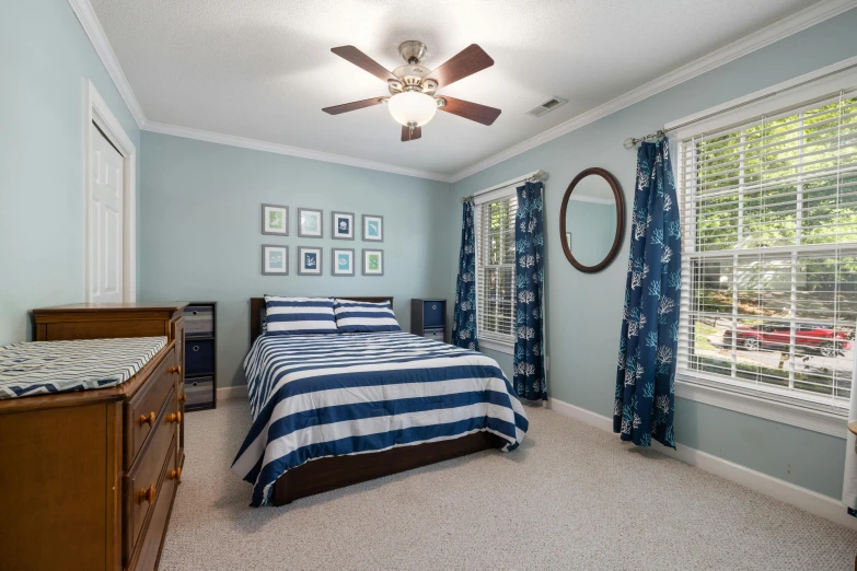 a blue bedroom with striped bedspread and blue curtains