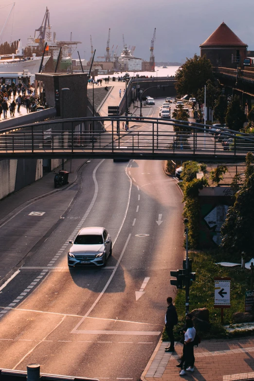 cars moving on a freeway near people walking across the bridge