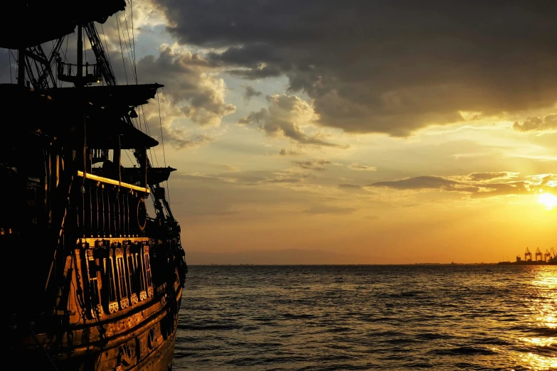 the setting sun sets over a ship in the sea