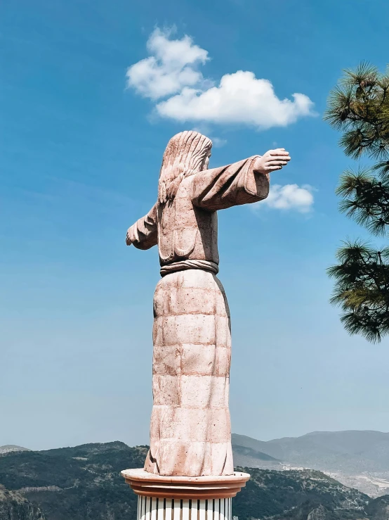 a statue on top of a cement block in the shade