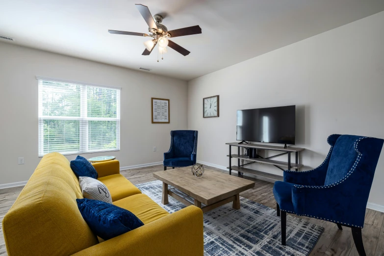 a living room with yellow furniture and a flat screen tv