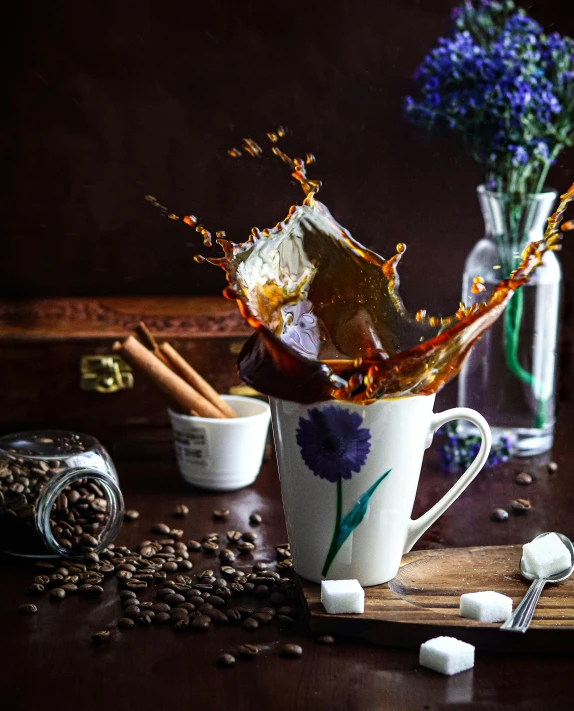 a coffee cup has ice and flowers in it