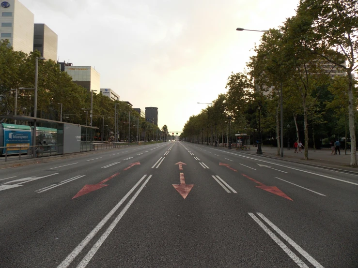 a wide empty road with red arrows in the middle