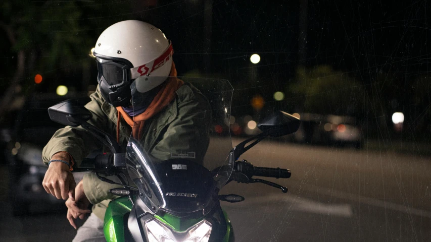 man riding on motorcycle wearing helmet and holding handlebars