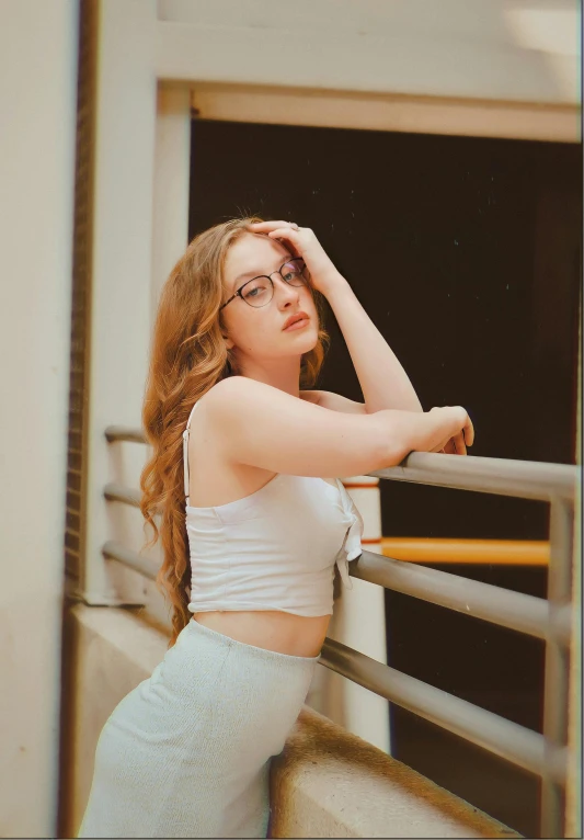 a woman standing near a railing with her arm resting on a railing