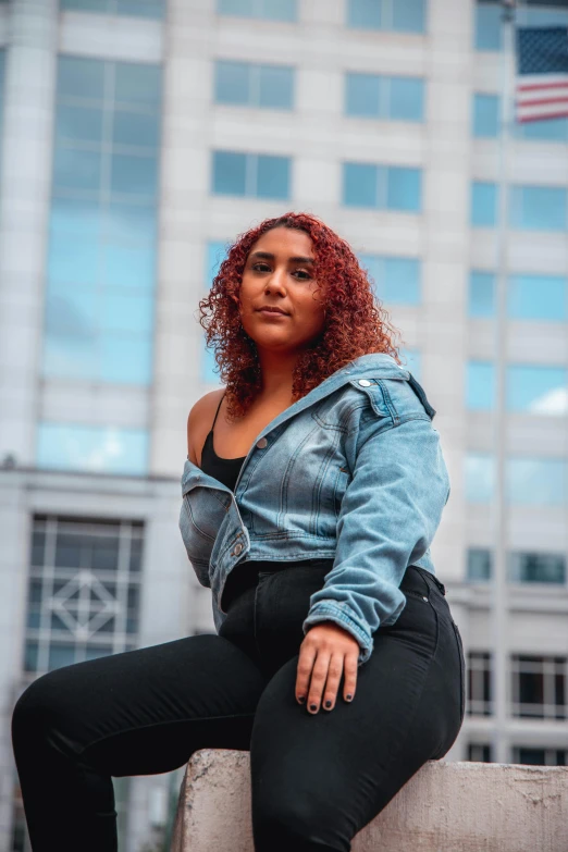 a young woman is posing on a concrete structure