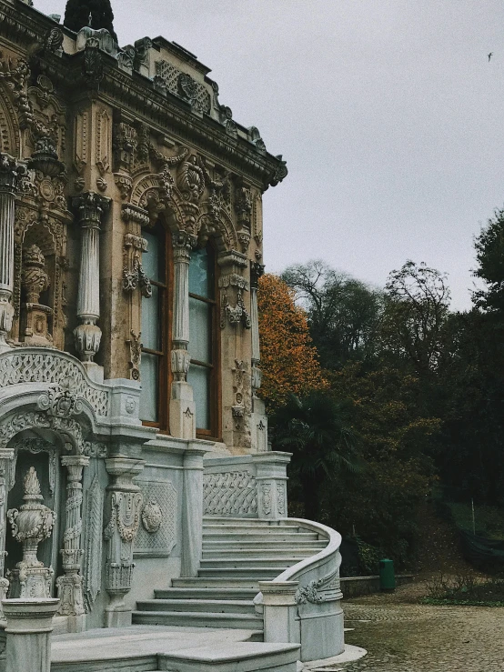 the marble stairs outside of an ornate stone building