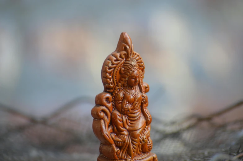 a carved wooden statue sitting on a surface