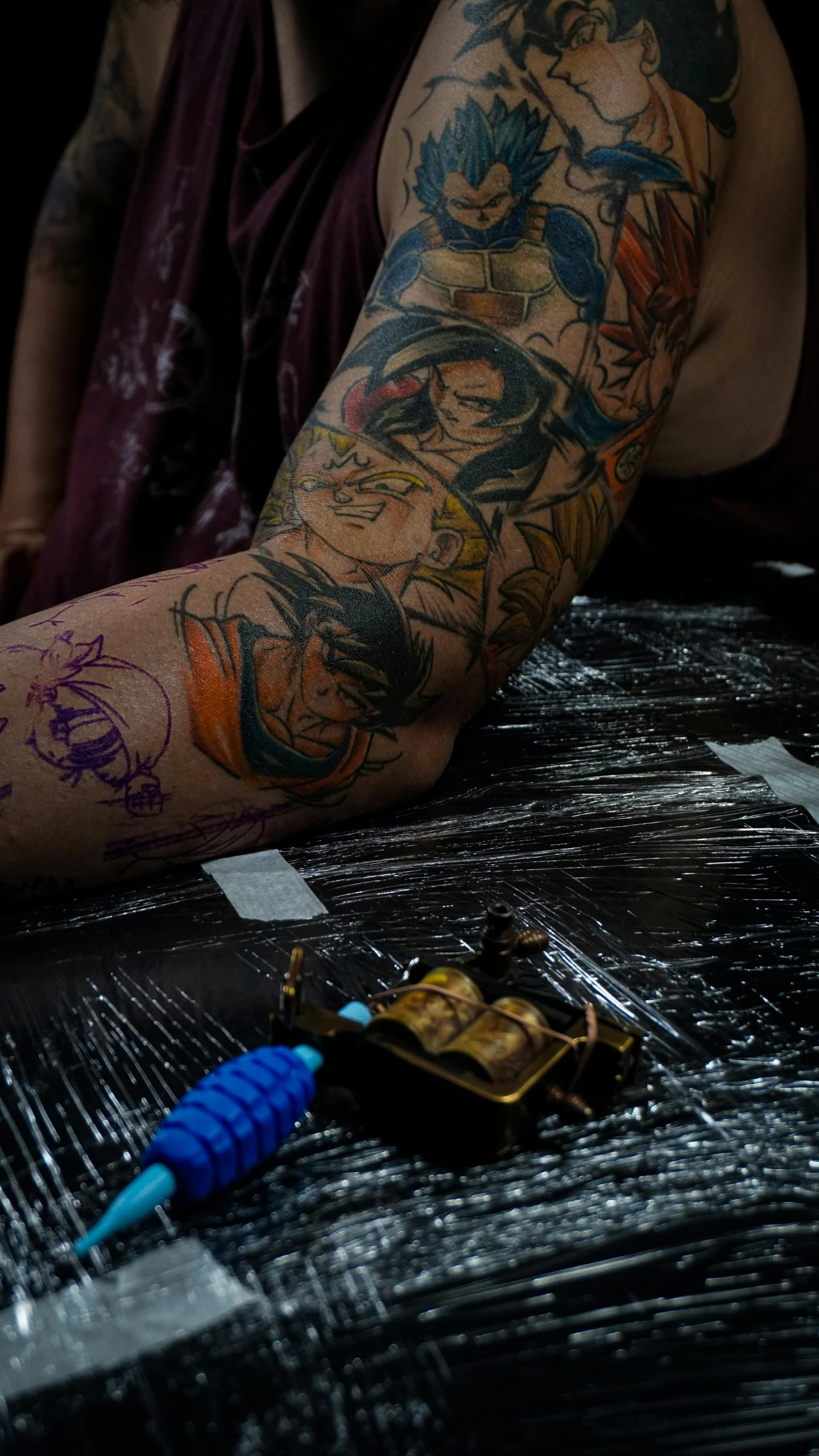 a man with tattoos sitting at a table