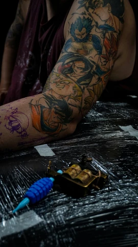 a man with tattoos sitting at a table