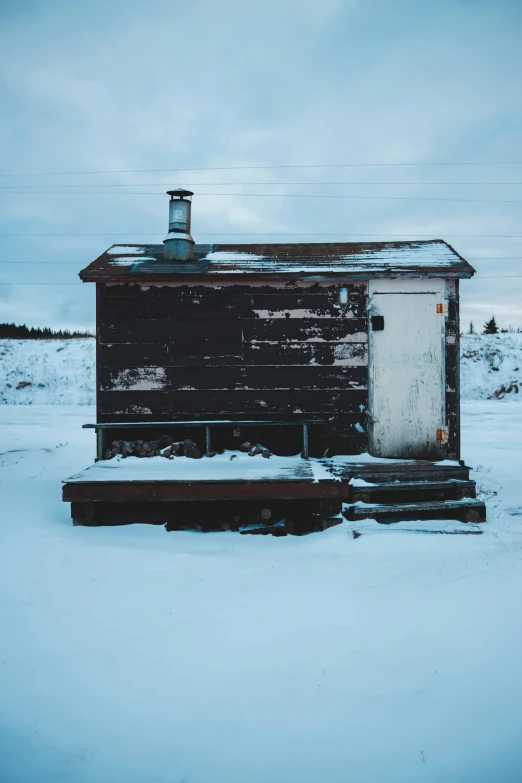 the side of a black building on snow covered ground