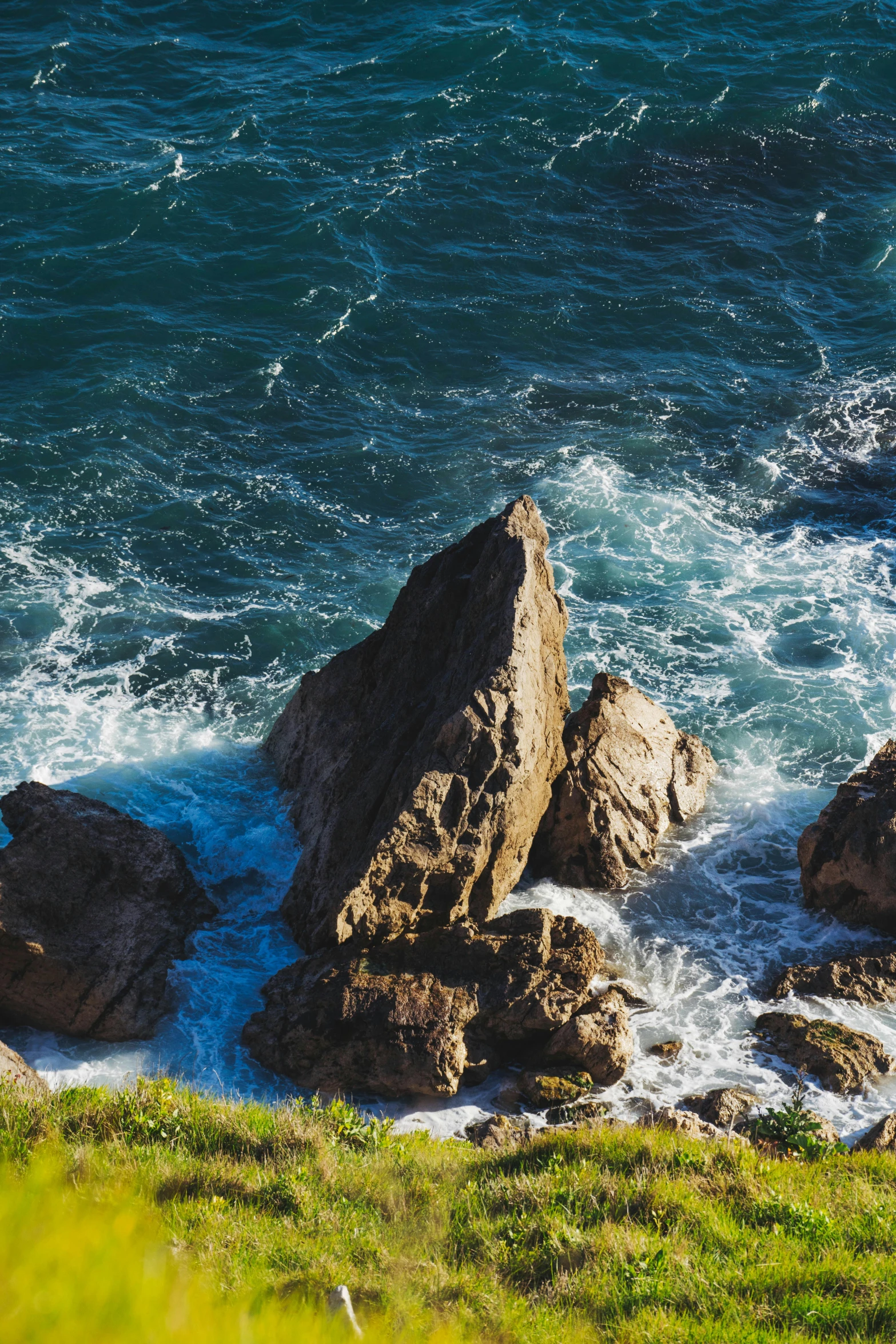 the ocean waters are crashing against some rocks