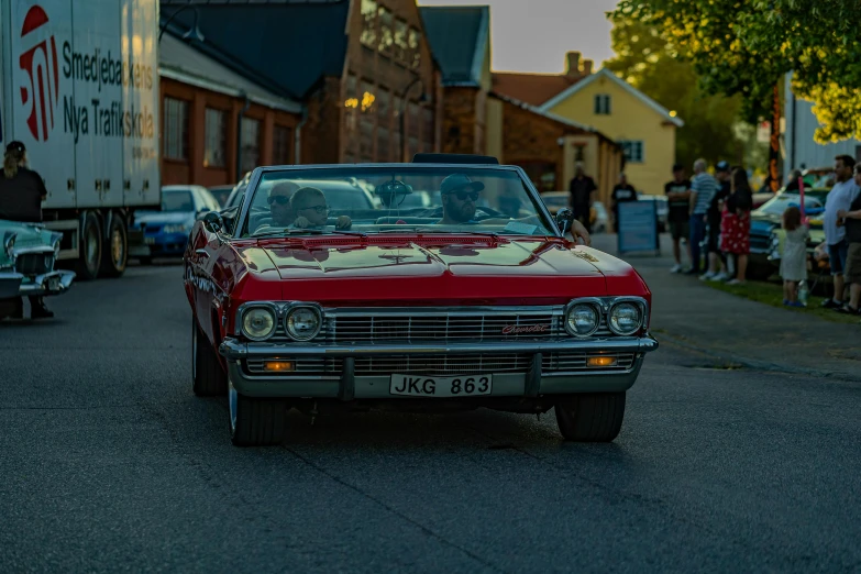 a red vintage car parked in front of a building