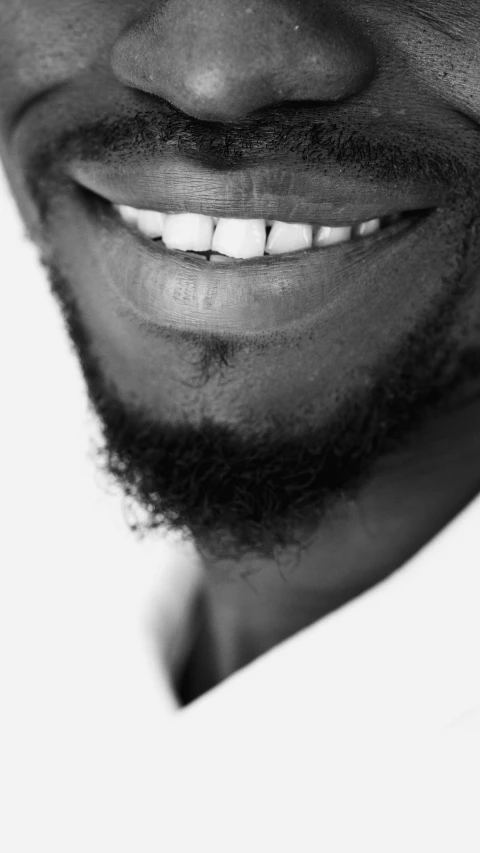 the smiling black man has a beard and large white smile