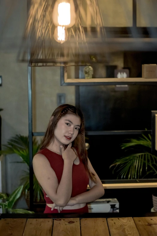 a woman in a red shirt standing at a table