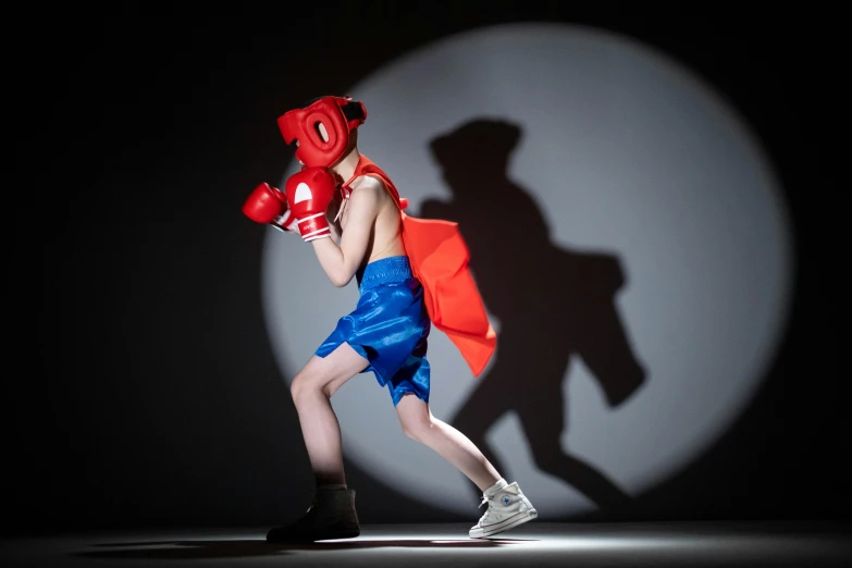 a person with a red boxing mitt in a shadow on the wall