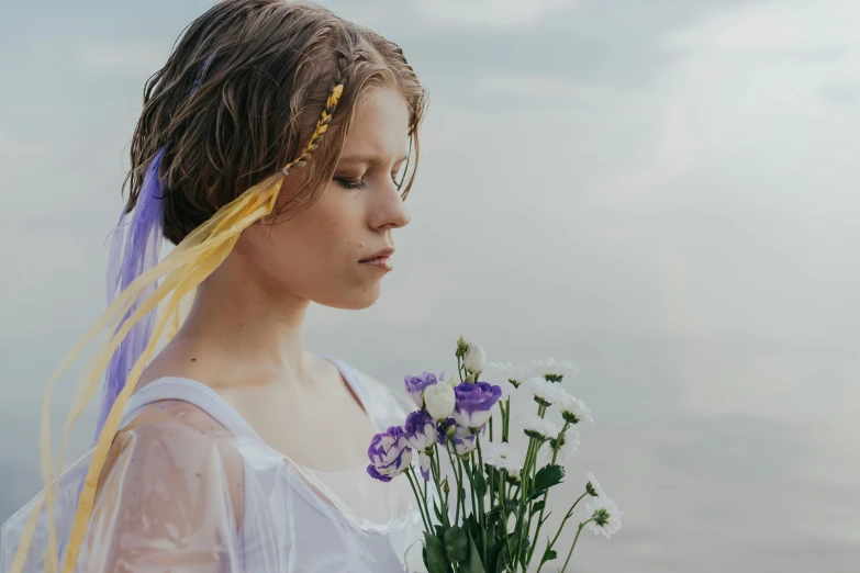 a woman with long hair holding purple flowers and yellow ribbons