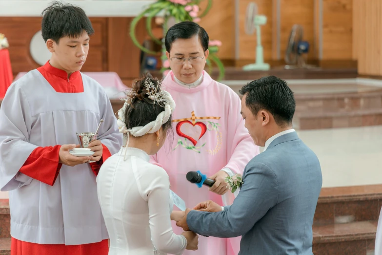 priest taking wedding vows to groom during ceremony