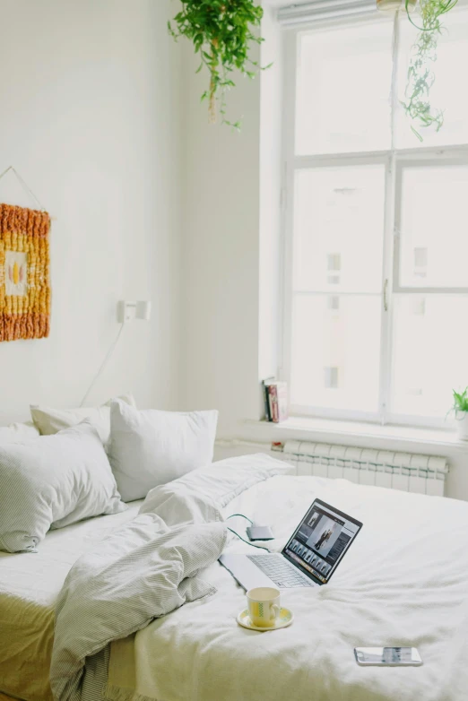 a laptop on top of a bed with pillows and blankets