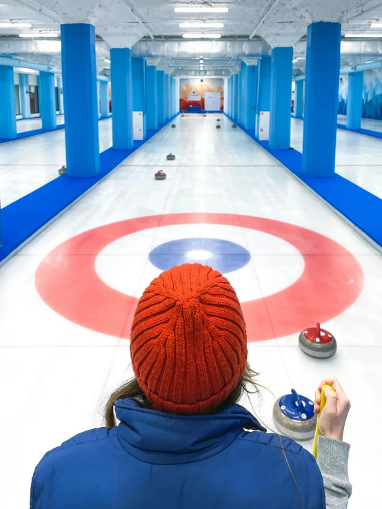 an adult holding a curling game in a long hall