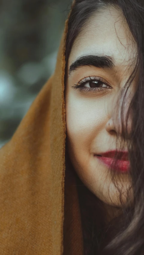 a girl smiles while wrapped in a blanket