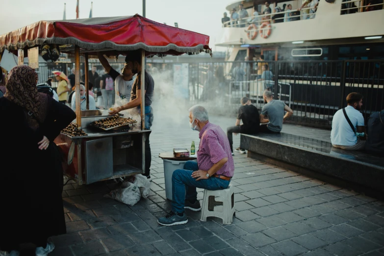 a man cooking  dogs in the open air