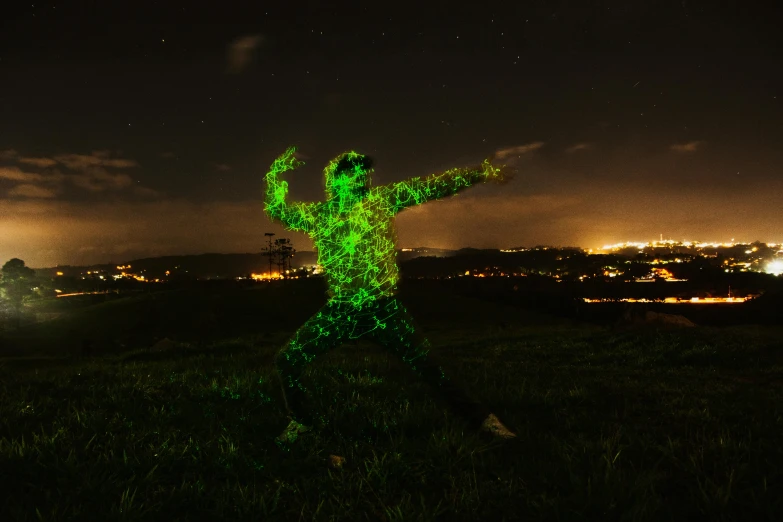 an illuminated person stands in a field with a view of the night