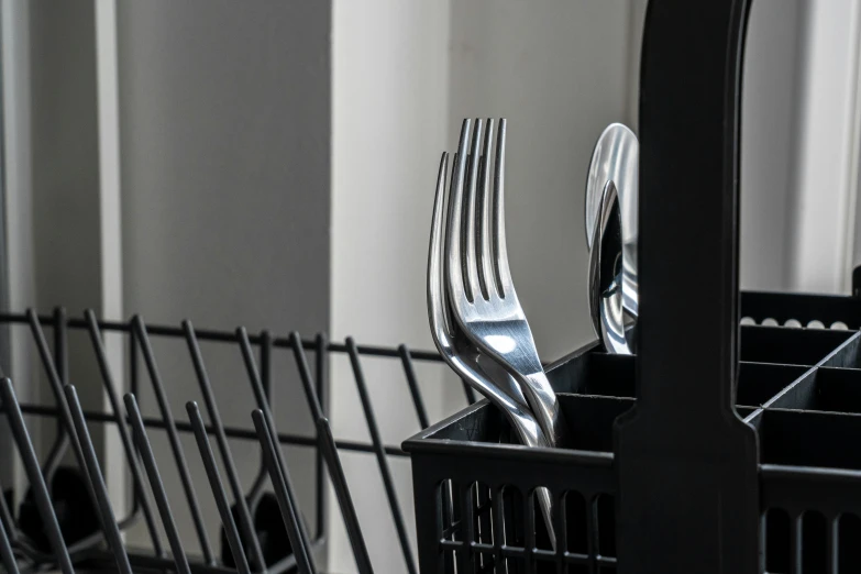 there is a set of silverware in an open black tray