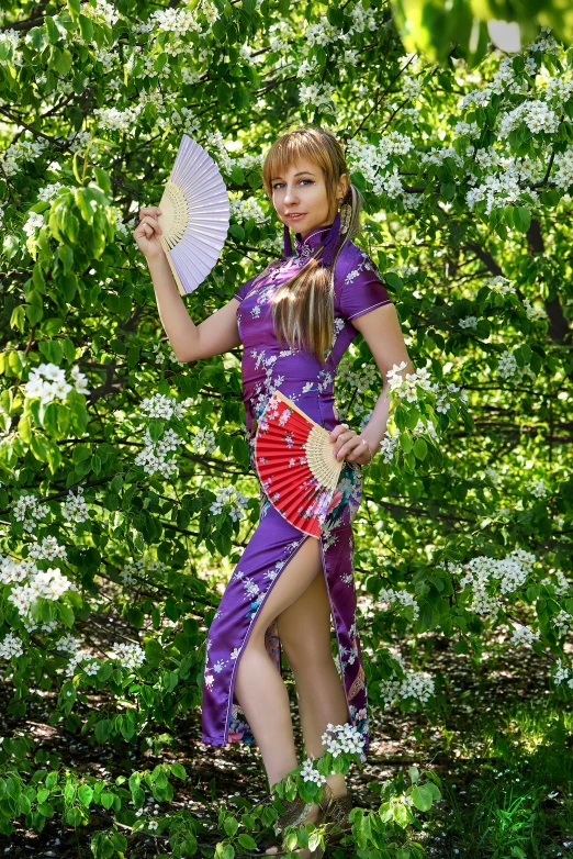 woman in oriental dress and fan, walking through the woods