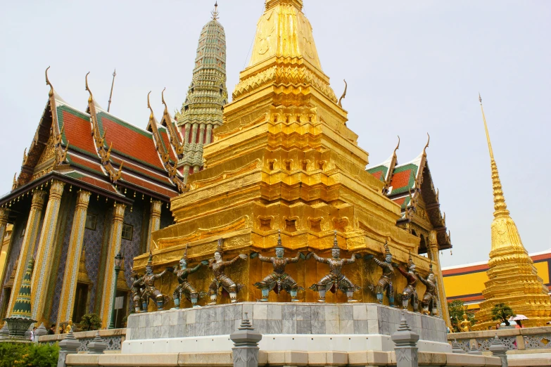 a very tall ornate building with gold painted and red roof tops