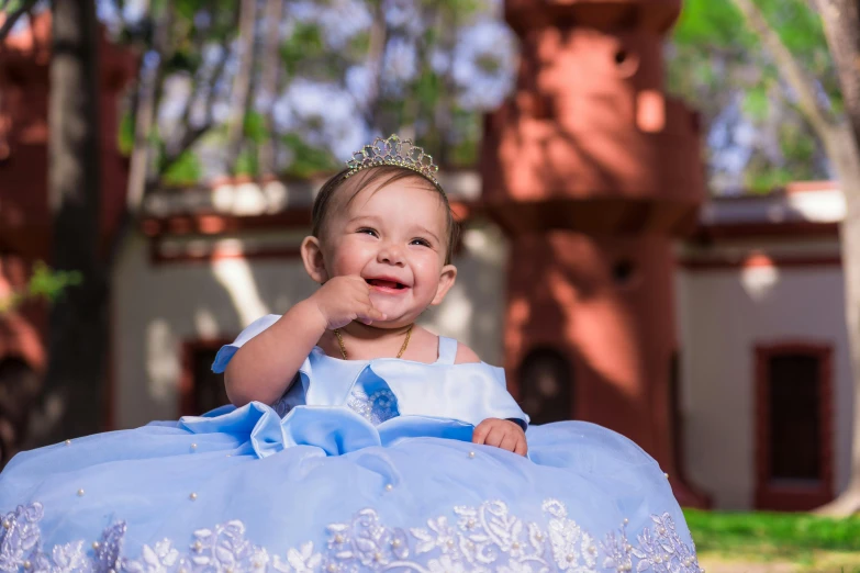 a baby with a tiara wearing a blue dress