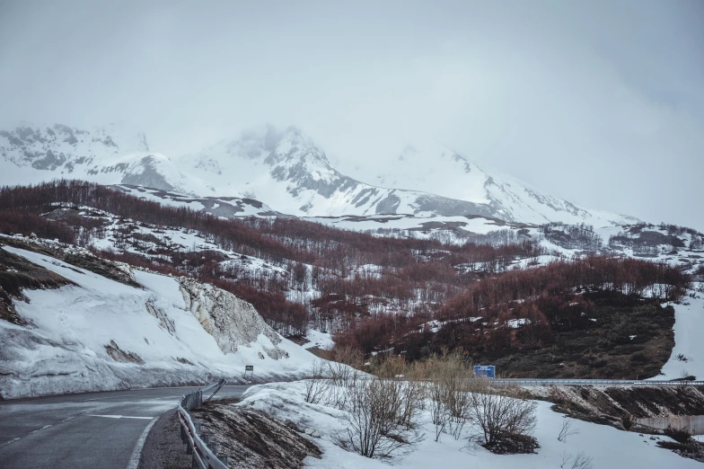 a snowy mountain landscape with a road and snow