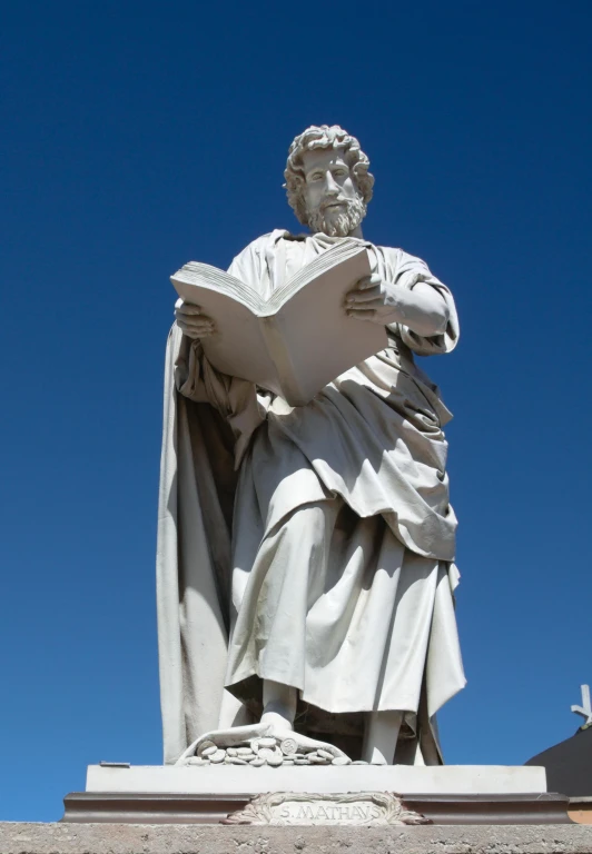 a statue of a man holding a book is seen here