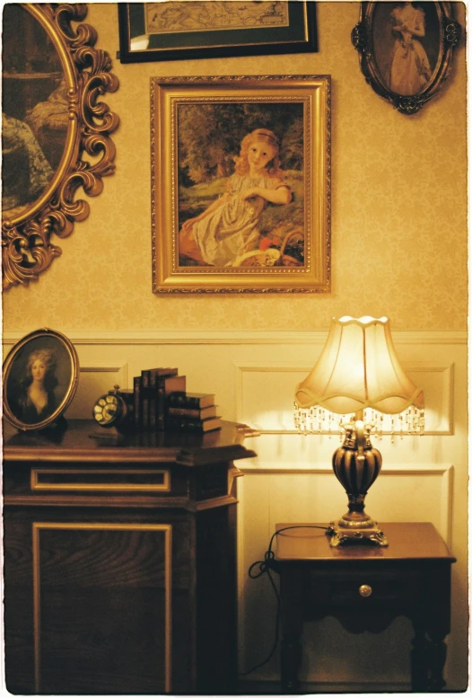 a living room with a lamp and some paintings on the wall