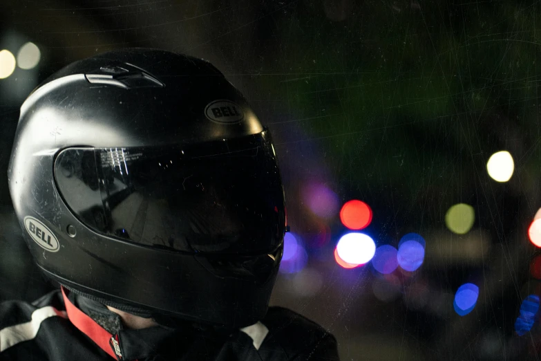 a person in a helmet stands outside at night