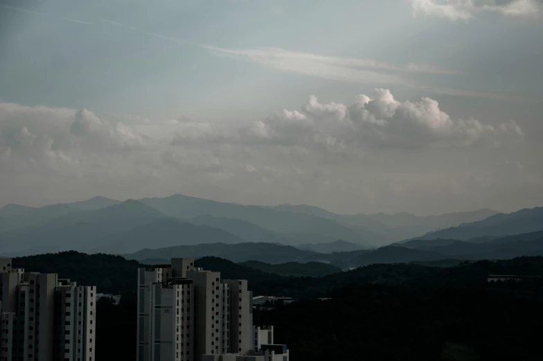 some buildings are shown with mountains and clouds in the background