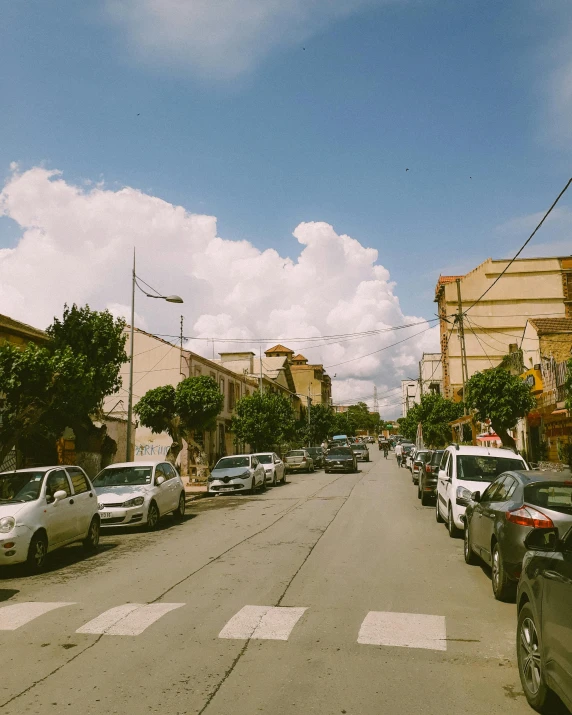 a street filled with traffic under a cloudy sky