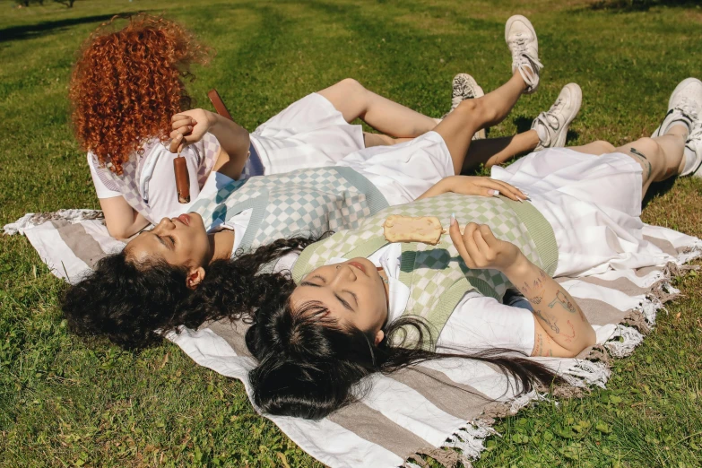 two woman laying on the ground together