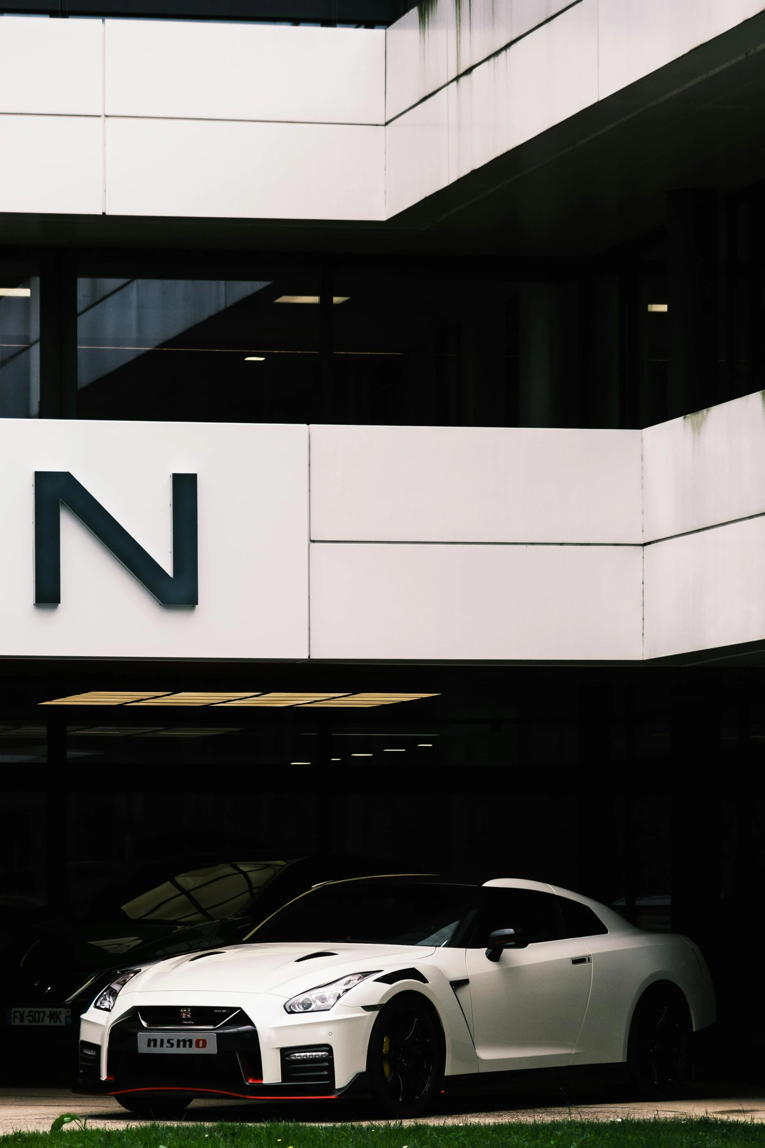 a white car parked in front of a modern building