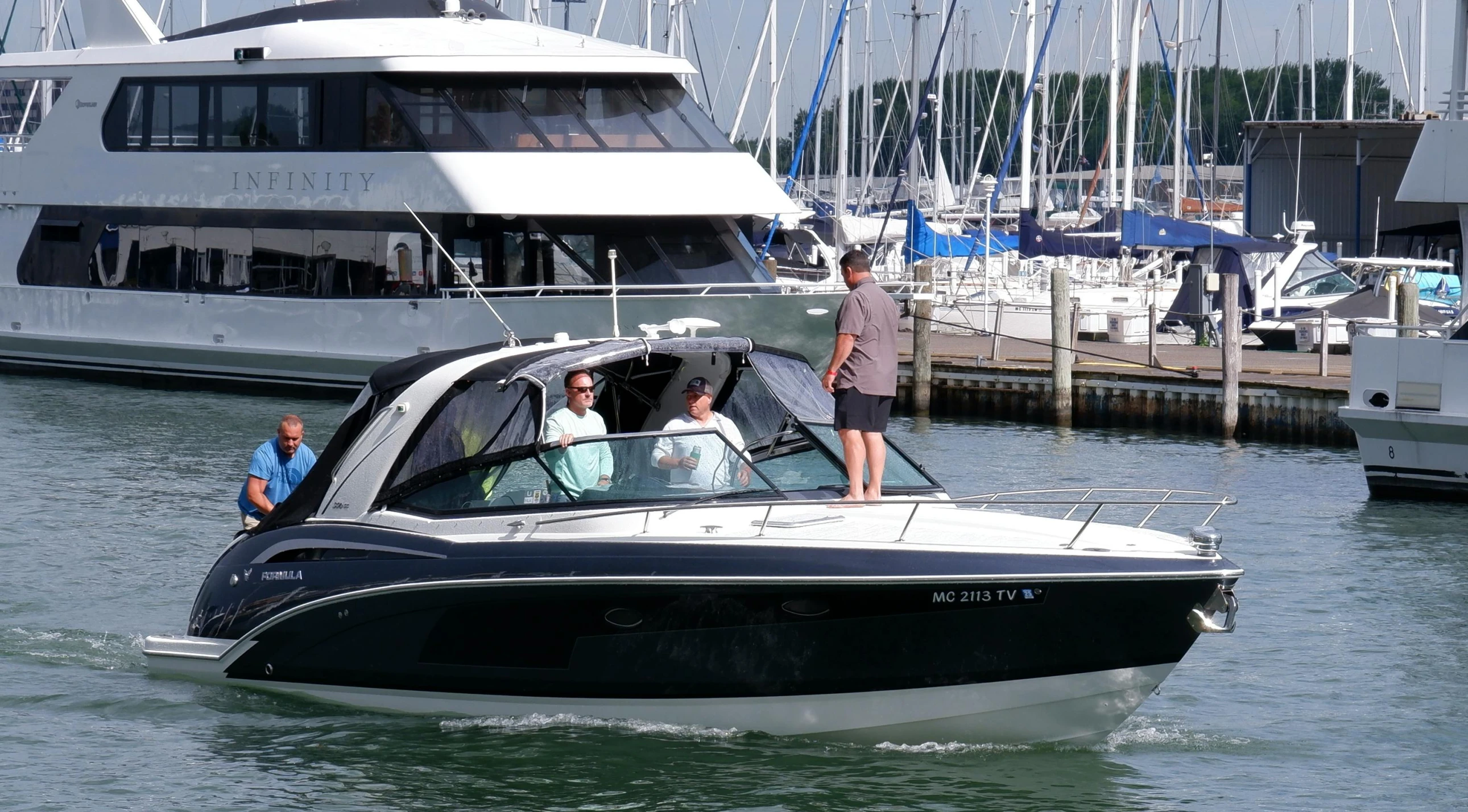 two people are standing on top of a black and white boat