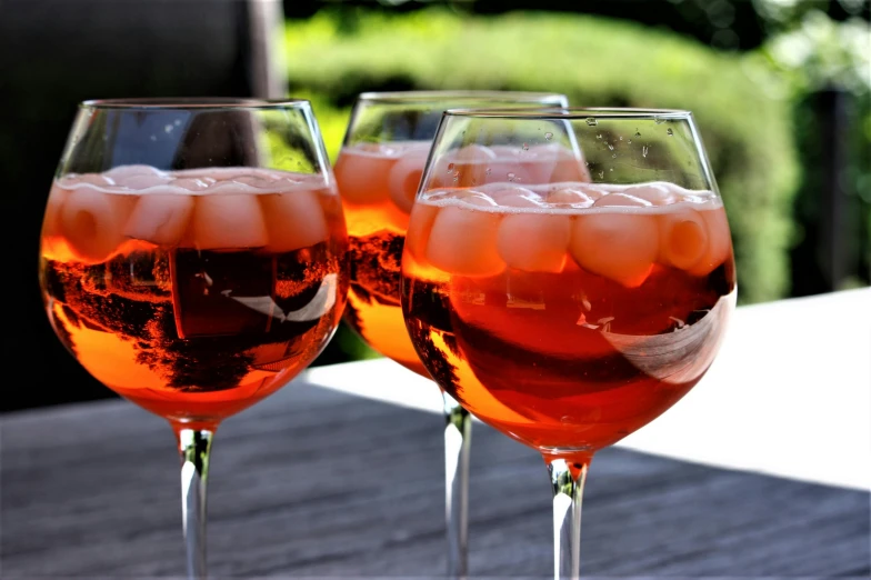 two wine glasses filled with beer on top of a wooden table