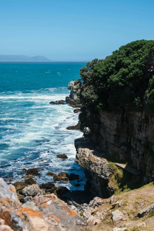 a person on a rock outcropping on the beach