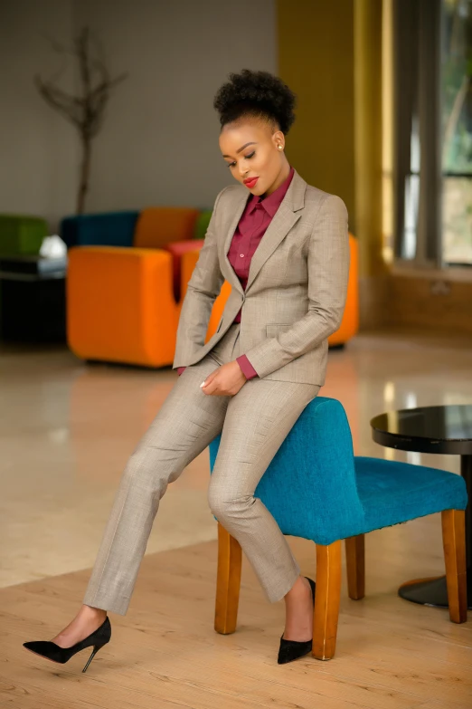 a woman in an office suit sitting on a chair