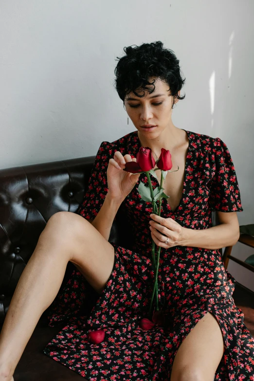 woman in black flowery dress sitting on brown sofa