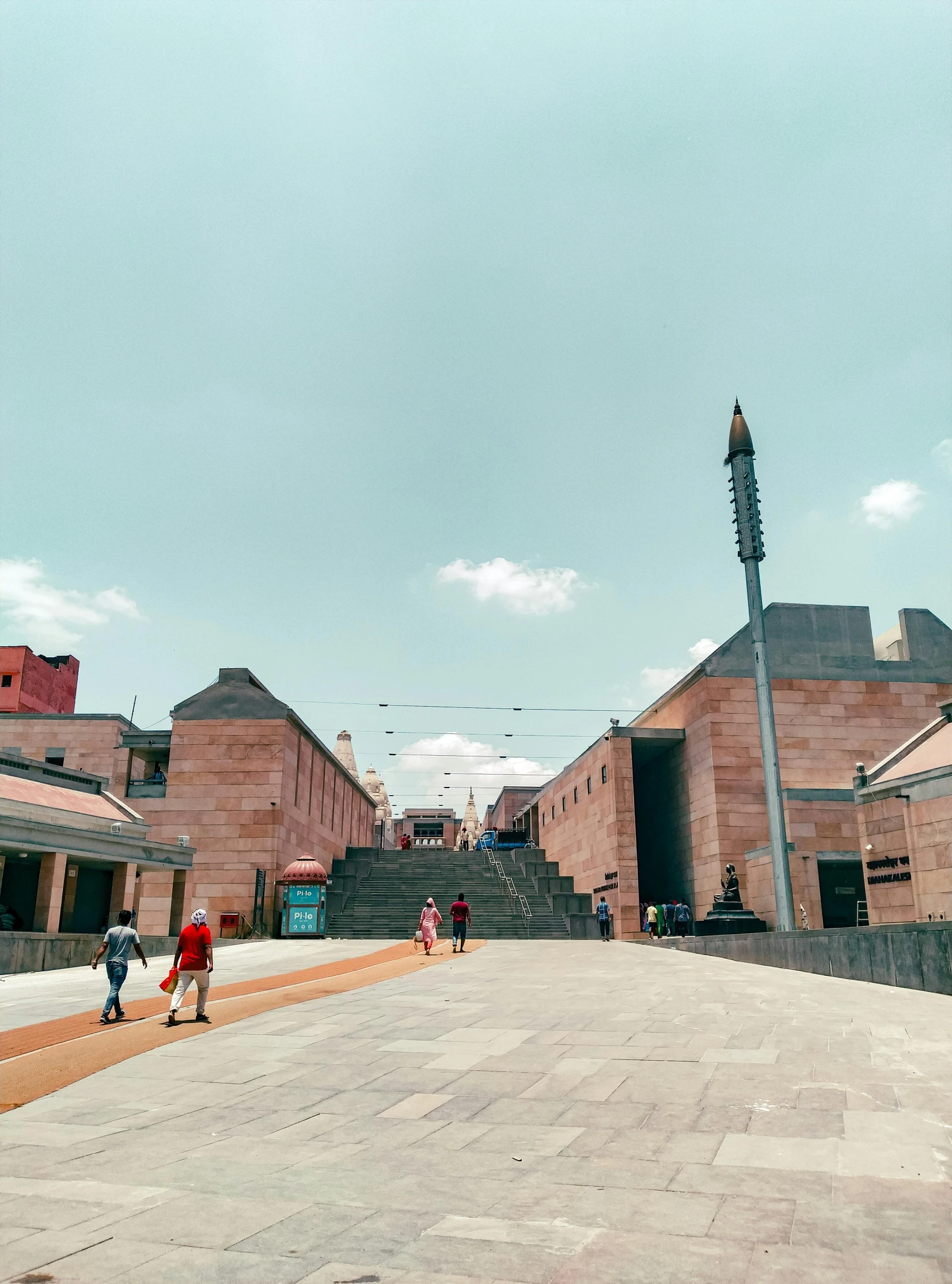 a city square with a large staircase, clock tower, and steps