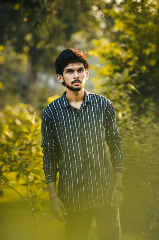 a man with a mustache standing in the woods