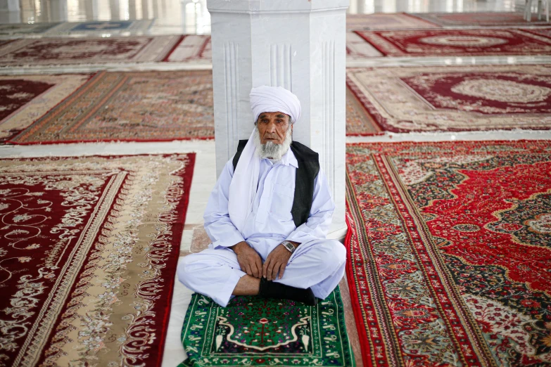 an old man sitting in a large white room