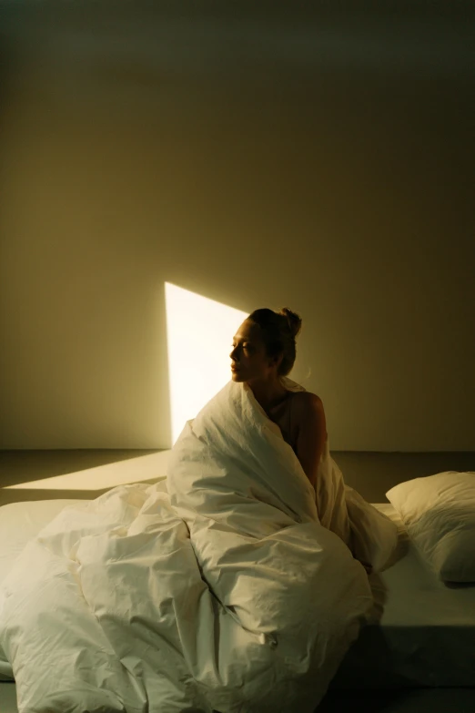 a young woman sitting on the edge of her bed