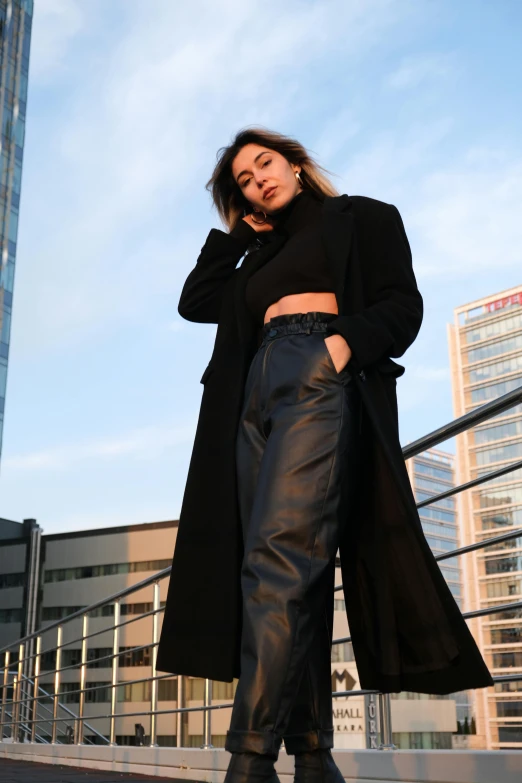 a woman in black leather pants and a coat