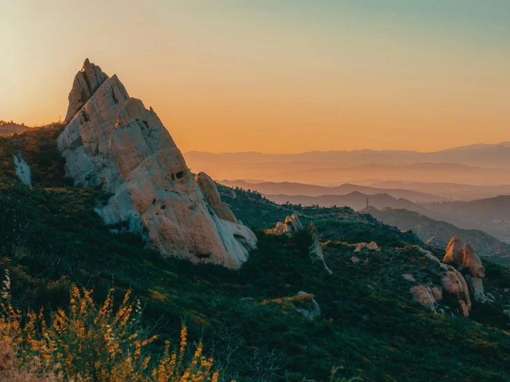 the sun setting on the mountains as well as rocks